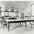 A laboratory room at the Volta Bureau with pictures, a large table, and chairs surrounding the table.