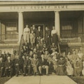 Group photo of men and women on steps of building.