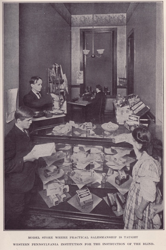 Three male and one female student holding items in model store.
