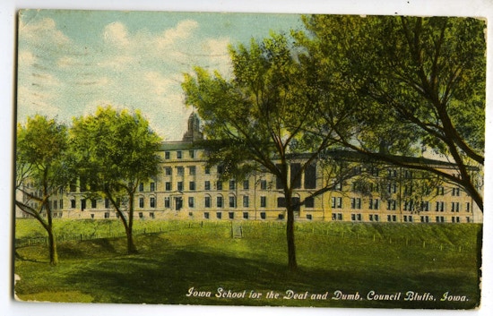 Iowa School For The Deaf And Dumb. A large building with grass and trees. A large building with dome, pillars, and trees.