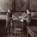 Photo of two young male students studying a map of the United States.