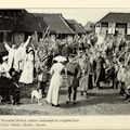 Soldiers march past disabled children and nurses in an English village.