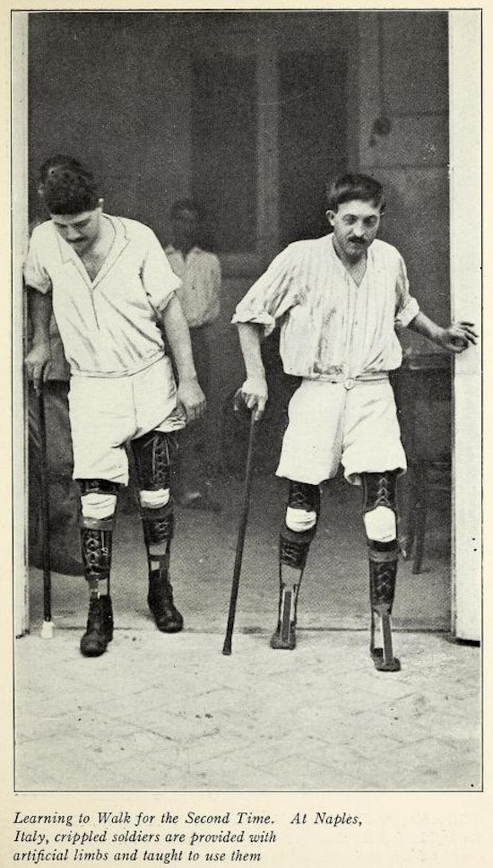 Two men, both amputees, walking with prosthetic legs.