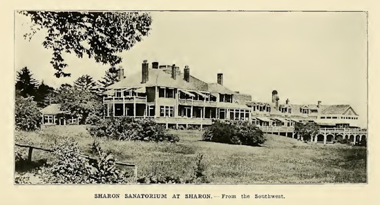 Photograph of large sprawling building with many windows, porches, and decks.