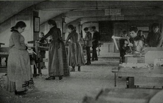 Young men and women in woodworking shop.