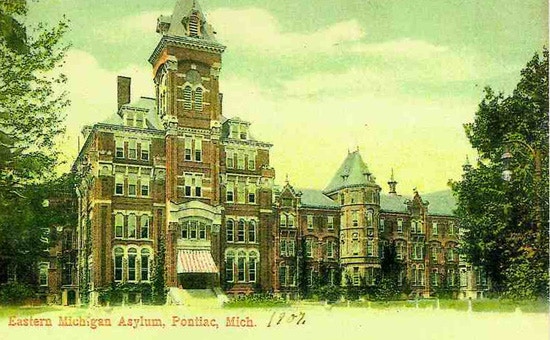 Color postcard of huge asylum in background with large courtyard in front