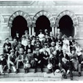 A group of men and women sit on the steps of Chapel Hall at the National Deaf-Mute College ( later renamed Gallaudet University ).