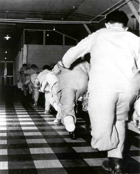 View from behind of a line of lower leg amputees performing balance exercises