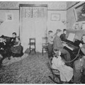 Deaf students and teachers in a parlor with a piano.