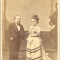 A short-statured man and woman, both formally dressed.
