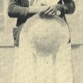 An African-American woman wearing a white dress.