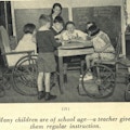 Six children, two in wheelchairs, examine a globe, their teacher in the background.