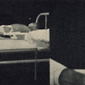 A boy lies in bed wearning splints.