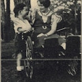 A woman in a wheelchair putting her arm around a boy.