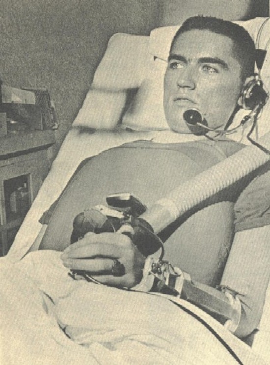 A man with a telephone headset and a respirator chestpiece.