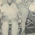 A young man in a wheelchair with his wife and young daughter.