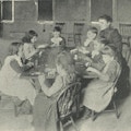 Seven children and a teacher sit around a table.