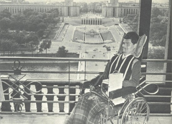 With Paris in the background, the author smiles from his wheelchair.