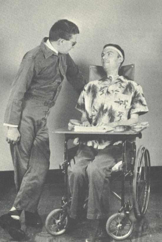 A young man in a wheelchair with a blind friend.