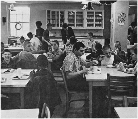 Children eating in a small dining hall.