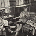 Three women sits and talk. One has a crutch and braces. Another has a cane.