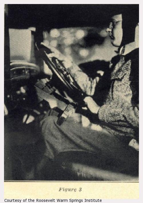 A man sits at a steering wheel.
