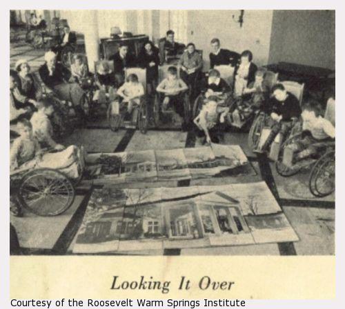 Children in wheelchairs surround a large completed puzzle of Geogia Hall at Warm Springs.