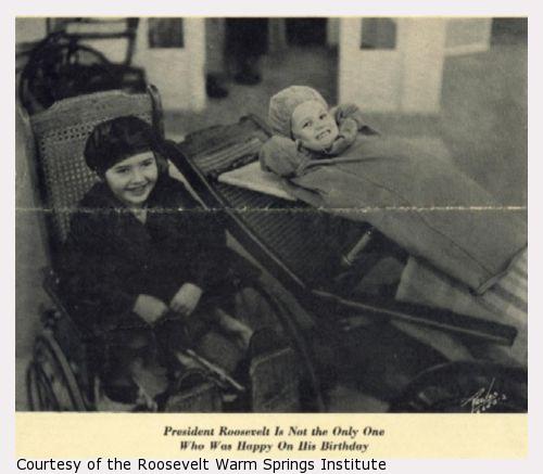 Two smiling children in wheelchairs, one reclining.