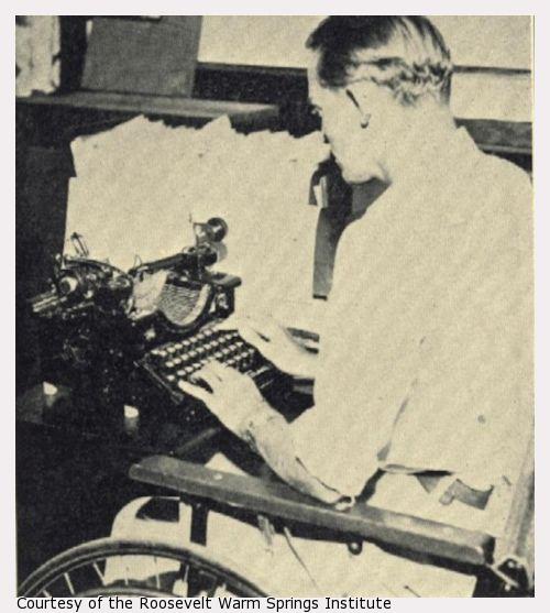 A man in a wheelchair typing.