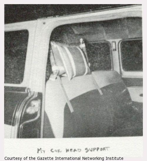 A photograph of a car seat with a homemade head support.