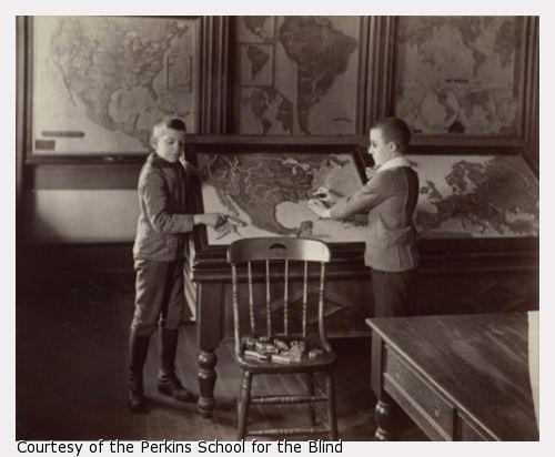 Photo of two young male students studying a map of the United States.