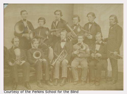 Perkins students, boys in suits, with band instruments.