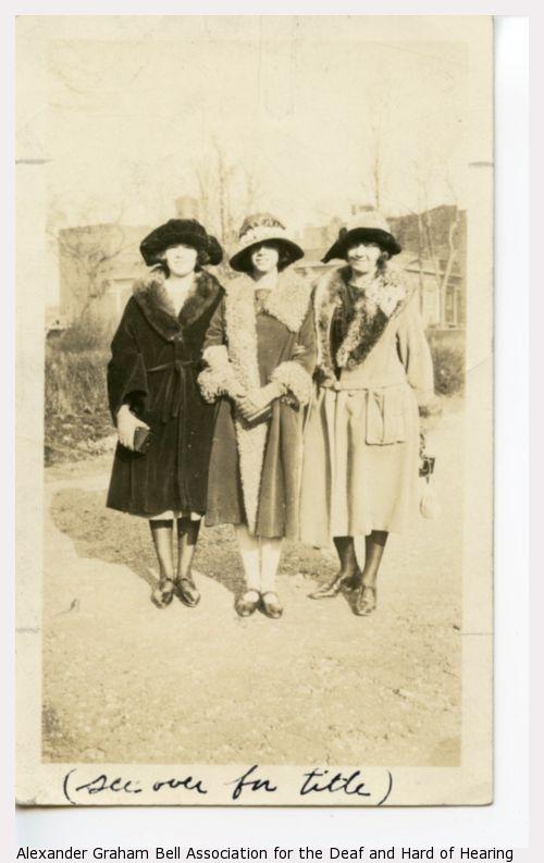 Three women, probably either teachers or alumni, standing arm in arm.