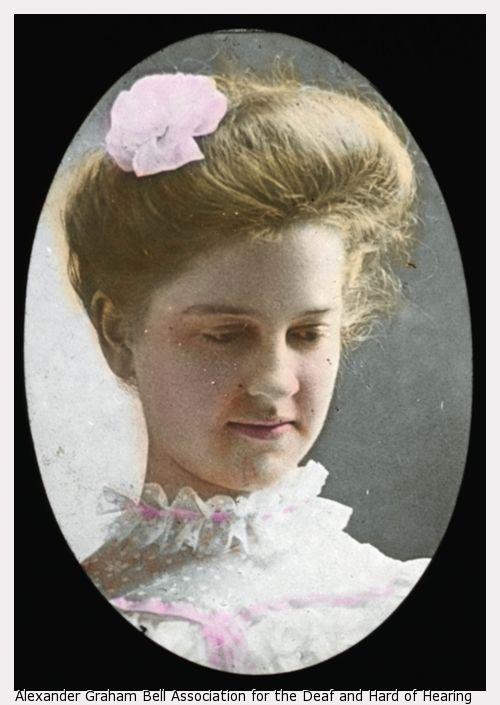 Mildred Keller with ruffled collar, looking down and to right, colored.