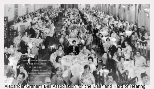 Group photograph of International Congress on the Education of the Deaf attendees sitting at large round tables in a banquet room.