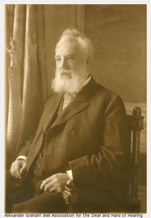 Alexander Graham Bell, seated, facing left, with white beard.
