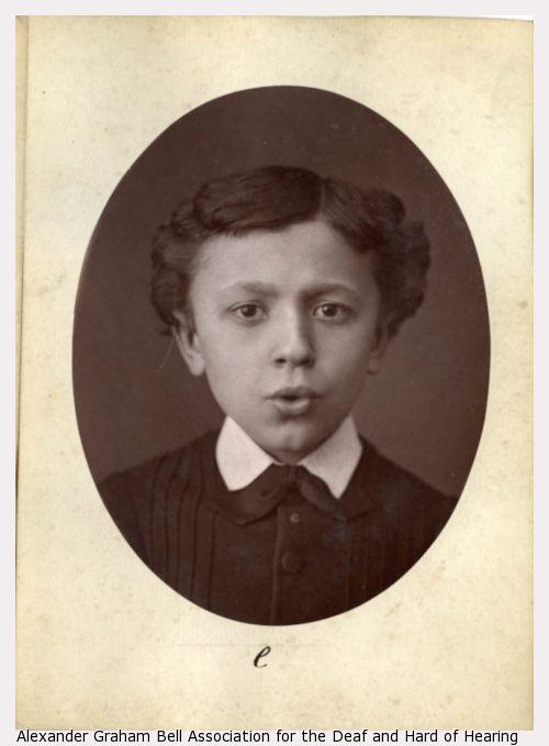 Photograph flashcard of a young boy demonstrating phonetic sounds by mouth movement.