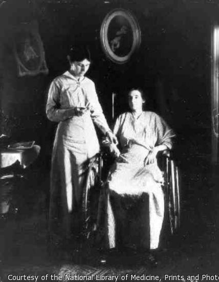 Woman in wheelchair having her pulse taken by nurse