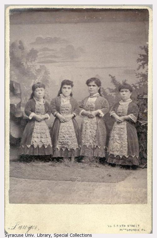 Four small-statured women standing.